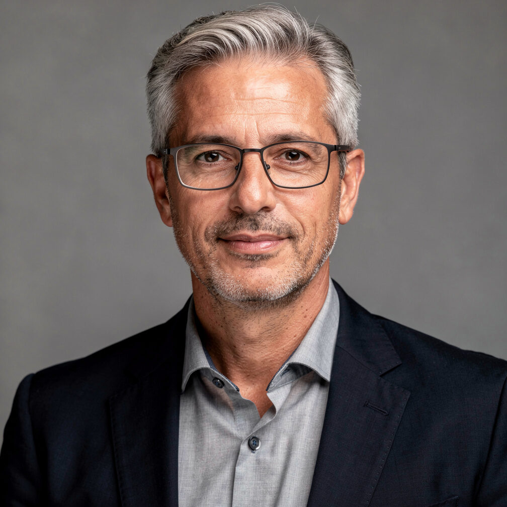 Studio portrait of an older Portuguese man with grey hair and glasses